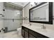Modern bathroom featuring a dual sink vanity, framed mirror, and glass enclosed shower with decorative mosaic tile at 5051 Silver Thistle Ln, St Cloud, FL 34772