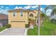 Charming two-story home featuring a two car garage, manicured lawn and lush tropical landscaping at 5051 Silver Thistle Ln, St Cloud, FL 34772