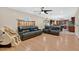 Open-concept living room featuring hardwood floors, a ceiling fan and an adjacent kitchen at 5051 Silver Thistle Ln, St Cloud, FL 34772