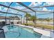 Screened pool with clear water, a covered lanai, a view of the lake and backyard, and a white picket fence at 5051 Silver Thistle Ln, St Cloud, FL 34772
