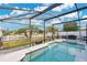Screened pool with clear water, a covered lanai, lush backyard, and a white picket fence at 5051 Silver Thistle Ln, St Cloud, FL 34772