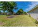 Spacious backyard with green grass and a large shade tree at 5379 Botany Ct, Orlando, FL 32811