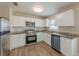 Well-lit kitchen offers stainless appliances, granite countertops, and modern white cabinetry at 5379 Botany Ct, Orlando, FL 32811