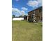 Spacious backyard featuring green grass, a playset, and a screened-in patio with a view at 5406 Crepe Myrtle Cir, Kissimmee, FL 34758