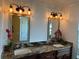 Bathroom featuring double sinks, granite countertops, and decorative lighting fixtures at 5406 Crepe Myrtle Cir, Kissimmee, FL 34758