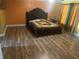 Bedroom with laminate flooring, a ceiling fan and orange walls at 5406 Crepe Myrtle Cir, Kissimmee, FL 34758