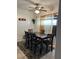Dining area with a dark wood table and chairs, accented by sheer curtains and modern light fixture at 5406 Crepe Myrtle Cir, Kissimmee, FL 34758