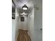 Well-lit hallway with hardwood floors, decorative lighting, and white doors and trim at 5406 Crepe Myrtle Cir, Kissimmee, FL 34758