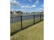 Picturesque lake view from the backyard, enhanced by an elegant black metal fence at 5406 Crepe Myrtle Cir, Kissimmee, FL 34758