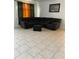 Tile-floored living room featuring a large, comfortable sectional and accent ottoman at 5406 Crepe Myrtle Cir, Kissimmee, FL 34758
