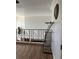 Loft area with hardwood floors, iron railings, and a decorative shelf, perfect for a cozy retreat at 5406 Crepe Myrtle Cir, Kissimmee, FL 34758