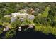 Aerial view of a home featuring a pool and private dock on a serene lake surrounded by lush greenery at 5479 Baytowne Pl, Oviedo, FL 32765