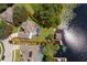 Aerial view of a home, pool, private dock, with lake access surrounded by lush landscaping at 5479 Baytowne Pl, Oviedo, FL 32765