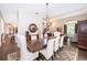 Formal dining area with chandelier, wood table with seating for six, and backyard views at 5479 Baytowne Pl, Oviedo, FL 32765
