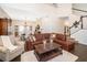 Bright living area with hardwood floors, a leather couch, and an open view to the dining room at 5479 Baytowne Pl, Oviedo, FL 32765