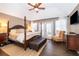 Serene main bedroom with a four-poster bed, ceiling fan, and access to a private outdoor space at 5479 Baytowne Pl, Oviedo, FL 32765