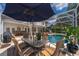 Sparkling pool with outdoor seating, covered patio, and manicured landscaping at 5479 Baytowne Pl, Oviedo, FL 32765