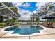 Refreshing pool area with outdoor dining and a view of the adjacent lake and beautiful landscaping at 5479 Baytowne Pl, Oviedo, FL 32765