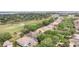 An aerial view of tile-roofed homes nestled near a golf course and a large lake at 6125 Foxfield Ct, Windermere, FL 34786