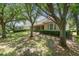 Landscaped backyard showcases mature trees, neatly trimmed hedges, and a charming covered patio at 6125 Foxfield Ct, Windermere, FL 34786