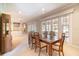 Dining room featuring a wood table set with seating for six, large windows, and access to the living area at 6125 Foxfield Ct, Windermere, FL 34786