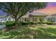 Well-maintained front yard with lush landscaping and a large shade tree enhancing the home's curb appeal at 6125 Foxfield Ct, Windermere, FL 34786