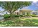 Well-manicured front yard with a large shade tree and manicured landscaping, complementing the home's exterior at 6125 Foxfield Ct, Windermere, FL 34786