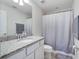 Clean and bright bathroom featuring a single sink vanity with granite countertop and a shower with curtain at 676 Bishop Bay Loop, Apopka, FL 32712