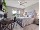 Cozy bedroom features a large bed, a desk, and a bright window offering plenty of natural light at 676 Bishop Bay Loop, Apopka, FL 32712