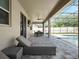 Covered patio with a ceiling fan, outdoor dining set, and lounge chair, overlooking the screened-in pool area at 676 Bishop Bay Loop, Apopka, FL 32712