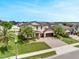 Well-manicured home with palm trees, a paver driveway, and a two-car garage under a blue sky at 676 Bishop Bay Loop, Apopka, FL 32712