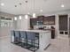 Bright kitchen boasts an island with pendant lighting and seating, stainless appliances, and granite countertops at 676 Bishop Bay Loop, Apopka, FL 32712