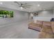 Expansive living room featuring plush carpeting, comfortable seating, a large ceiling fan, and a mounted flat screen television at 676 Bishop Bay Loop, Apopka, FL 32712