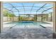 Screened-in pool with a mosaic-tiled spa and fountain, surrounded by a stone patio, perfect for outdoor relaxation at 676 Bishop Bay Loop, Apopka, FL 32712