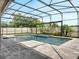 Screened-in pool with a mosaic-tiled spa and fountain, surrounded by a stone patio, perfect for outdoor relaxation at 676 Bishop Bay Loop, Apopka, FL 32712