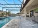 Screened-in pool with a mosaic-tiled spa and fountain, surrounded by a stone patio and covered patio with outdoor dining at 676 Bishop Bay Loop, Apopka, FL 32712