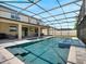 Screened-in pool with a mosaic-tiled spa and fountain, surrounded by a stone patio and covered patio with outdoor seating at 676 Bishop Bay Loop, Apopka, FL 32712