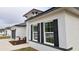 Detailed view of a home's exterior highlighting white paint, dark trim, and black shutters at 699 Marion Oaks Trl, Ocala, FL 34473