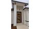Close up of an orange, three-pane modern front door with complementary sidelight and modern hanging lamp at 699 Marion Oaks Trl, Ocala, FL 34473