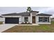 Charming single-story home featuring a dark garage door, orange front door, and freshly installed landscaping at 699 Marion Oaks Trl, Ocala, FL 34473