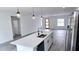 Bright kitchen with white cabinets, island with sink and gray floors, and stainless appliances at 699 Marion Oaks Trl, Ocala, FL 34473