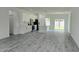 Spacious open-concept living room and kitchen featuring modern light gray flooring and lots of natural light at 699 Marion Oaks Trl, Ocala, FL 34473