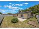 Large, fenced backyard featuring a concrete patio, lush lawn, and home with solar panels at 725 Laurel Way, Casselberry, FL 32707