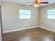A bedroom with neutral walls, bright windows, a ceiling fan, and wood-look floors at 725 Laurel Way, Casselberry, FL 32707