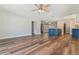 Open-concept living area with wood-look flooring, fan, and updated kitchen view at 725 Laurel Way, Casselberry, FL 32707