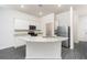 An open kitchen with stainless steel appliances, white cabinets, granite countertops, and a center island with sink at 914 Poppy Ln, Dundee, FL 33838