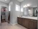 Bright bathroom with a wooden vanity, quartz countertop, framed mirror, and an adjacent closet at 921 Bradenville Ln, Winter Garden, FL 34787