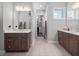 Bathroom showcasing double sink vanities with dark wood cabinets and a walk-in closet at 921 Bradenville Ln, Winter Garden, FL 34787