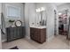 Charming bathroom with a grey vanity and storage cabinet, complemented by a large, round mirror at 921 Bradenville Ln, Winter Garden, FL 34787