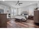Spacious bedroom with a tufted headboard, bench, and ample natural light for serene comfort at 921 Bradenville Ln, Winter Garden, FL 34787